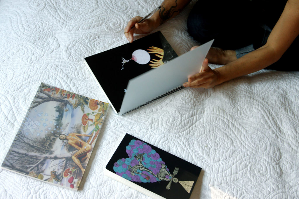 Collage notebooks and a greeting card on a bed