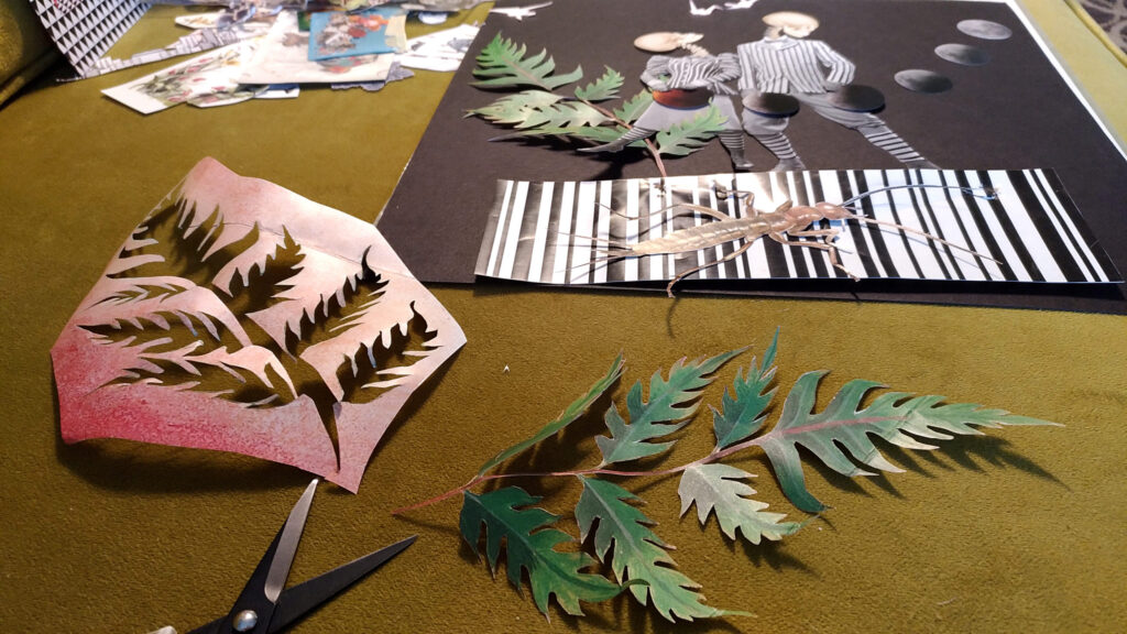 Paper wings and a fern laid out on the table